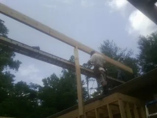 Carpenter setting a ridge beam over a new addition frame — Ice Dam Removal by Roofing Brothers in Salida