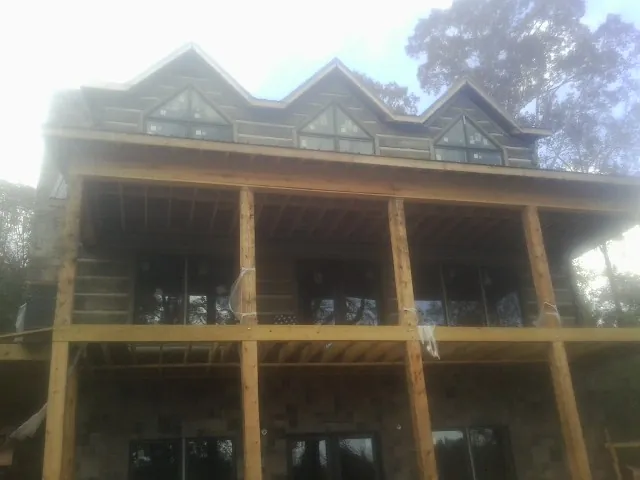 Dormers and porch framing on a large log home under construction — Roof Coating work by our crew in Salida